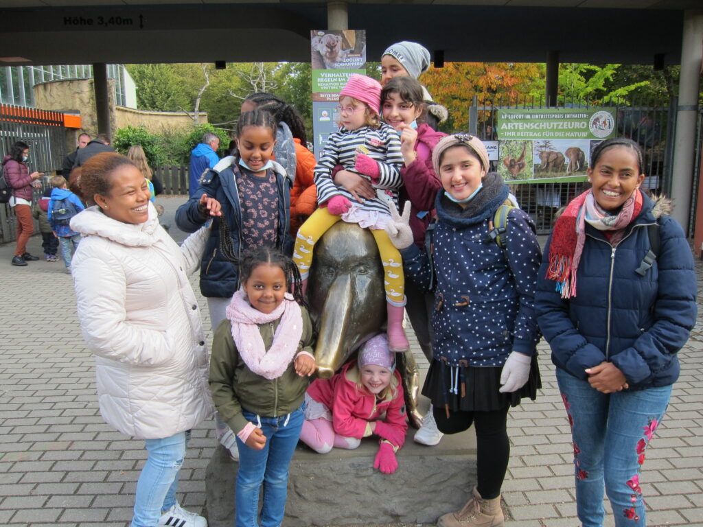 Eine Frau posiert mit einer Gruppe von Kindern vor einer kleinen Elefantenstatue